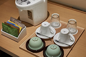 ミニバーに収納された茶器類をライティングデスク上にあらかじめセットできます。また、電気ケトルに加え、ボタンを押すだけで給湯可能な電気ポットのご用意もできます。（一般部屋でのご利用も可能）
